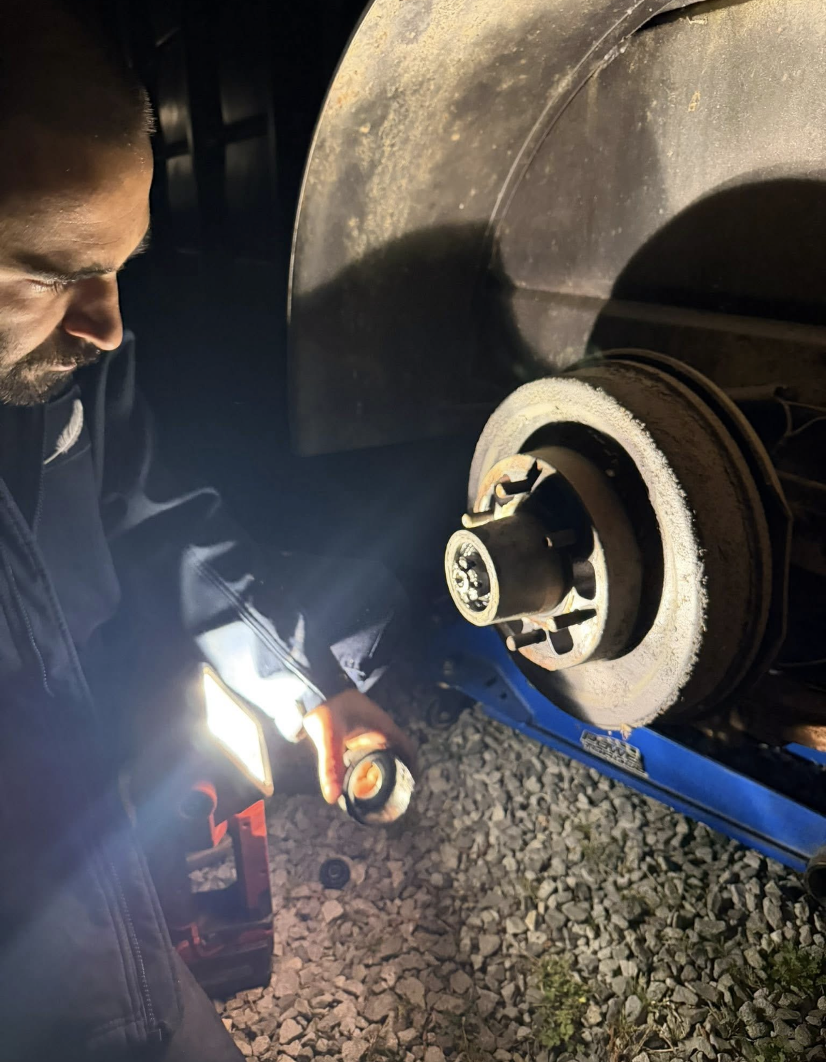Michael Tichow working on a vehicle at night